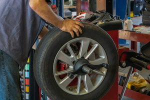 worker repairing tire at West Clinton Tire